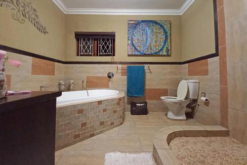a bathroom with a bath tub and a toilet at Marks Cottages in Durban