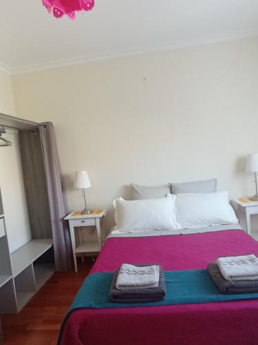 ヴィラ・ノーヴァ・デ・フォス・コアにあるCASA SENHORA DA VEIGAのベッドとタオル2枚のある寝室