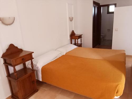 a bedroom with a bed and a wooden nightstand at Estudio 02 - Turístico Jasmund in San Fernando