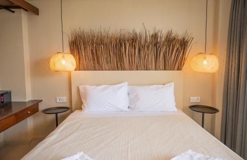 a bedroom with a bed with two tables and two lights at Atma Beach Rooms & Suites in Faliraki