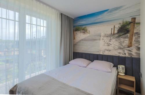 1 dormitorio con 1 cama y una pintura de playa en Pokoje Salsa en Dąbki