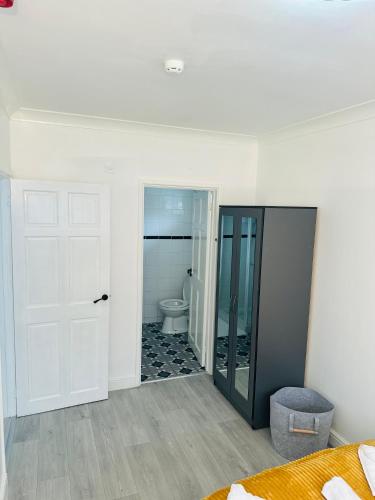 a bedroom with a bathroom with a toilet and a door at Cozy Haven Your Perfect 1Bed LE2 in Leicester