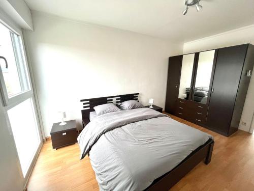 a bedroom with a large bed and a large window at M037 Marquer Joli T2 in Ambilly