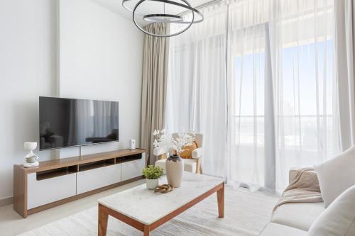 a living room with a television and a table at Silkhaus Vacation Homes Modern 2BDR Near Reem Mall in Abu Dhabi