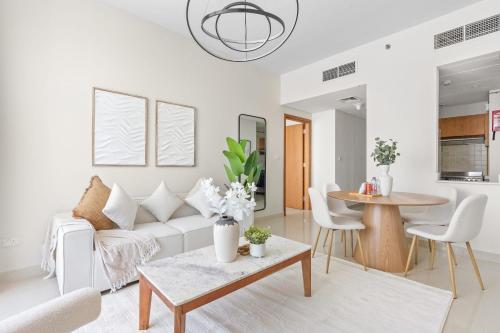 a living room with a white couch and a table at Silkhaus Vacation Homes Modern 2BDR Near Reem Mall in Abu Dhabi
