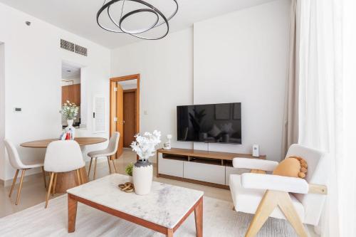 a living room with white furniture and a tv at Silkhaus Vacation Homes Modern 2BDR Near Reem Mall in Abu Dhabi