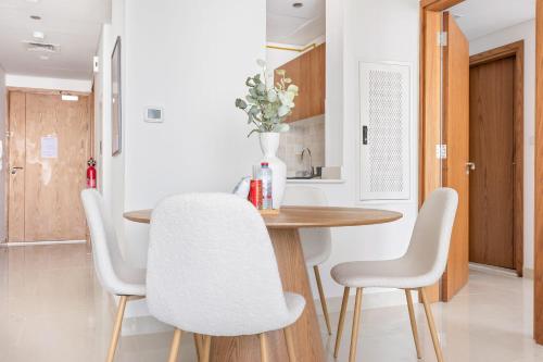 a kitchen and dining room with a table and chairs at Silkhaus Vacation Homes Modern 2BDR Near Reem Mall in Abu Dhabi