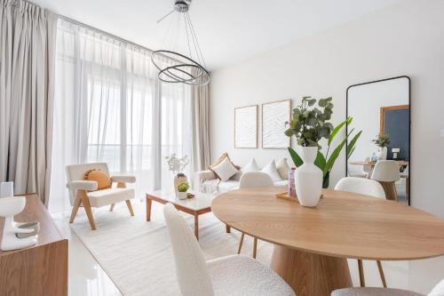 a white living room with a table and chairs at Silkhaus Vacation Homes Modern 2BDR Near Reem Mall in Abu Dhabi
