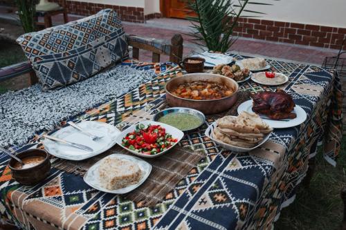 una tavola con piatti di cibo su un tavolo di A R A B I A Golden Palace a Luxor