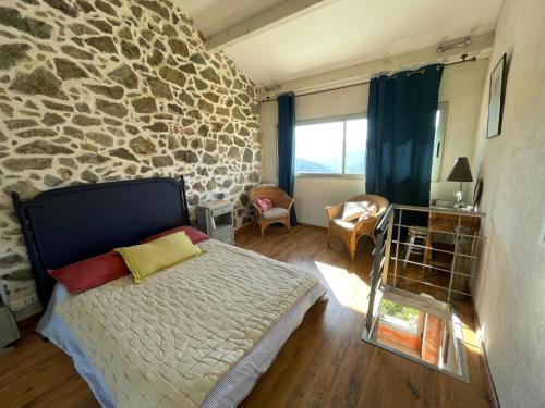 une chambre avec un lit et un mur en pierre dans l'établissement Letia Noce, à Chidazzo