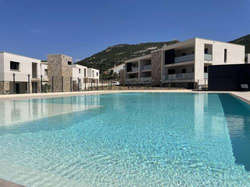 une grande piscine devant un immeuble dans l'établissement T2 dans résidence avec piscine, à Calvi