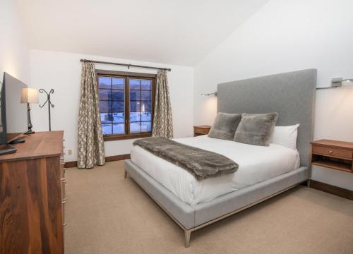 a bedroom with a bed and a tv and a window at Wildflower Place Unit 5 in Edwards