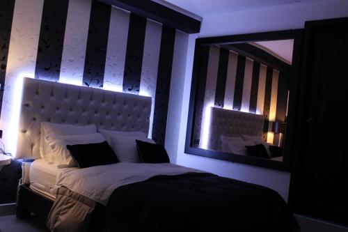 a bedroom with a large bed and a mirror at Hotel Venecia in Huánuco