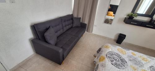 a couch in a living room next to a bed at Casa el conquistador/ExcelenteUbicación/2Hab/Wifi in Mérida