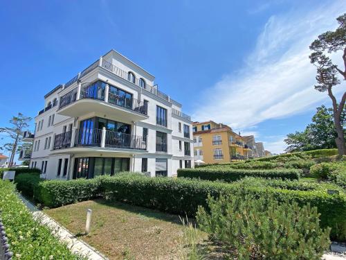 a large white building with bushes in front of it at Strandvilla Andrea Whg 07 Meerblick mit Balkon in Baabe