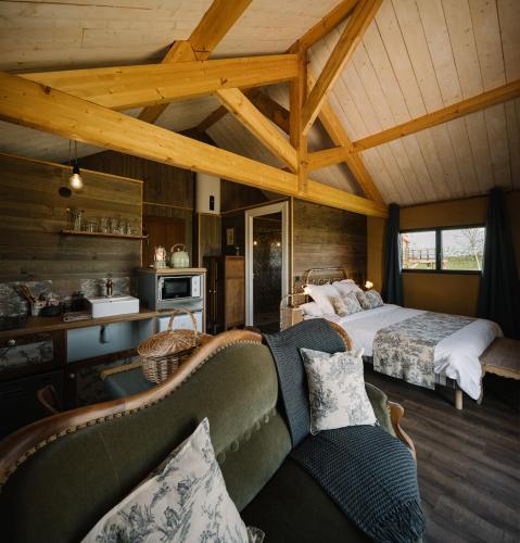 une chambre avec un lit et un canapé dans une pièce dans l'établissement Les Cabanes Du Lizon, à Bernadets-Dessus