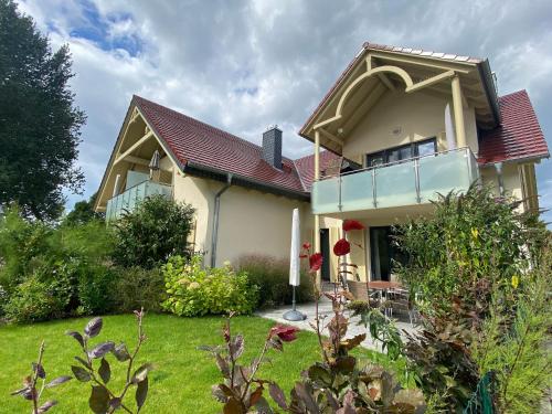 ein Haus mit einem roten Dach und einem Hof in der Unterkunft F Haus Sterntaucher Whg 01 mit Terrasse in Thiessow