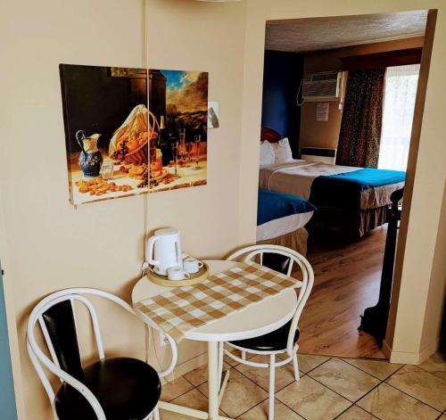a room with a table and chairs in a hotel room at Hotel Motel Granby in Granby