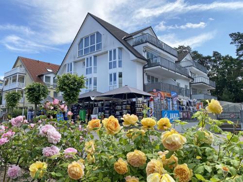 un grande edificio bianco con dei fiori di fronte di Ferienwohnung 06 Strandkieker mit Balkon a Baabe