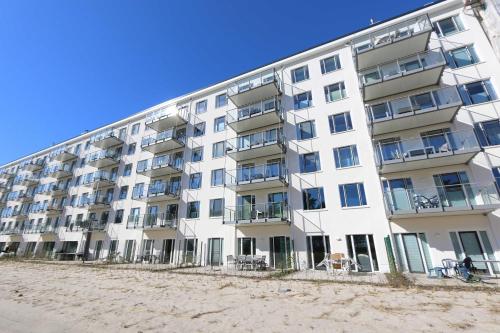 a white building on the beach next to the sand at Haus Granitz Whg. 5.3 mit Dachterrasse und Sauna in Binz