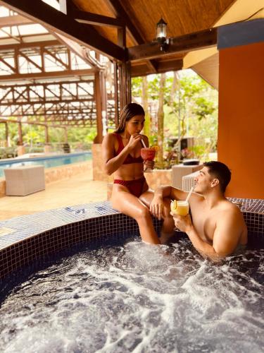 a man and a woman sitting in a hot tub at Ávita Lodge in Quesada