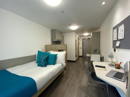 Un dormitorio con una cama y un escritorio con una computadora portátil. en Student-Only Accommodations in Belfast, en Belfast