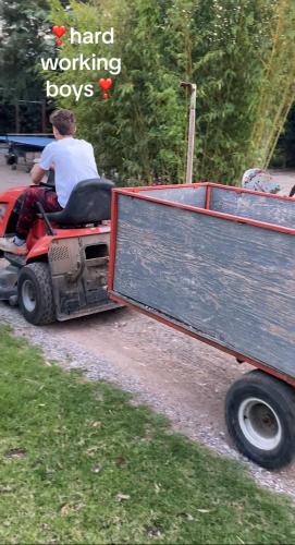 two men riding on a tractor with a trailer at Lavender farm house in Nafpaktos