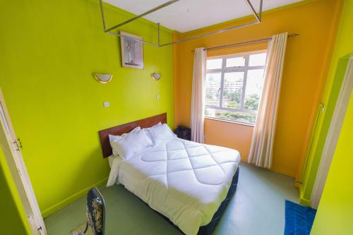 1 dormitorio con paredes de color verde y amarillo y 1 cama en Hotel Southern Blue, en Nairobi