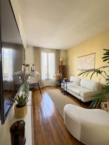 un salon avec un canapé blanc et une table dans l'établissement Appartement La Défense, à La Garenne-Colombes