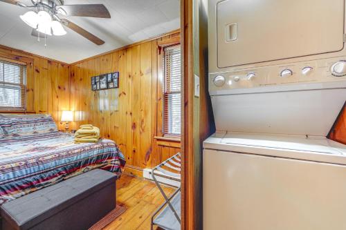 a bedroom with a bed and a washer and dryer at Pet-Friendly Creekside Cabin with Pool Access! in Maggie Valley