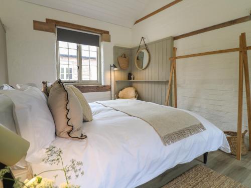 a bedroom with a white bed and a window at Ash Cottage - Fold Yards in Belper