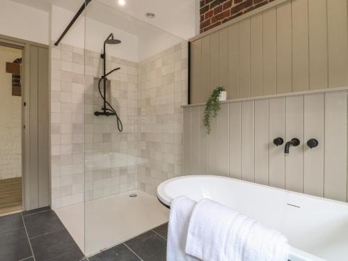 a bathroom with a bath tub and a shower at Ash Cottage - Fold Yards in Belper
