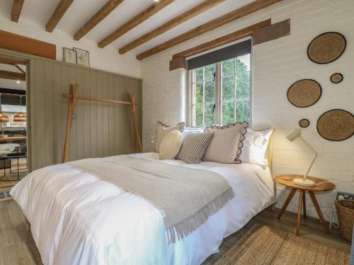 ein Schlafzimmer mit einem großen weißen Bett und einem Fenster in der Unterkunft Holly Cottage - Fold Yards in Belper