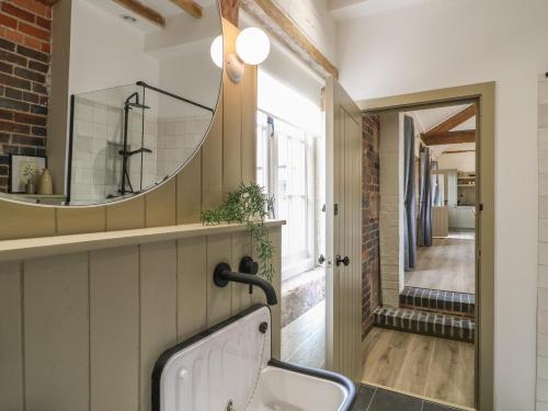 a bathroom with a sink and a mirror on the wall at Hazel Cottage - Fold Yards in Belper