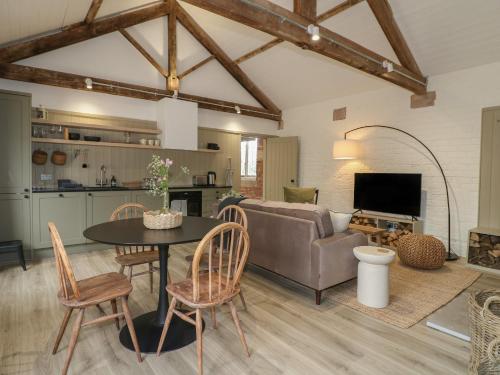 a living room with a couch and a table and chairs at Alder Cottage - Fold Yards in Belper