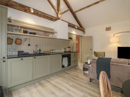 a kitchen and living room with a couch and a table at Alder Cottage - Fold Yards in Belper