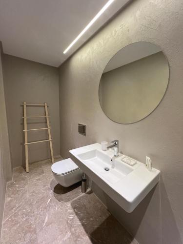 a bathroom with a sink and a toilet and a mirror at Viva Properties in Ouranoupoli