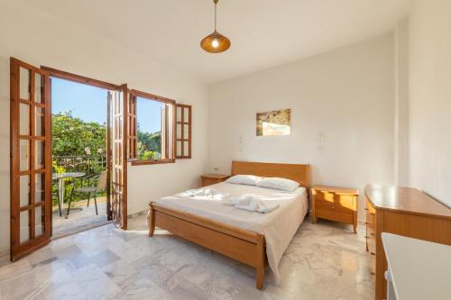 a bedroom with a bed and a large window at Ζini 2 in Kefalos