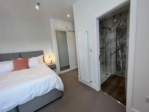 um quarto com uma cama e uma cabina de duche ao nível do chão em Carrick Rooms em Port Saint Mary