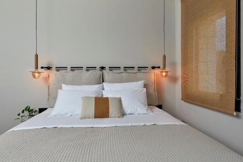 Un dormitorio con una cama con sábanas y almohadas blancas. en Hermes Residence, en Parga