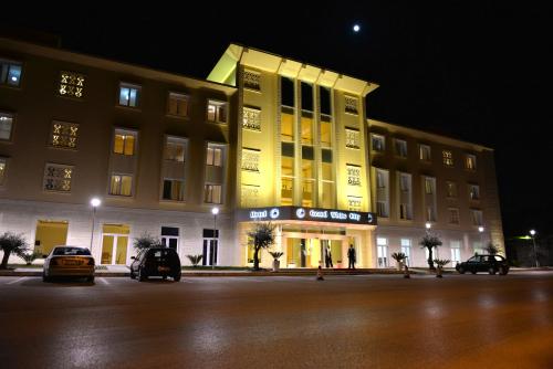 a building with a yellow light on the side of it at Grand White City Hotel in Berat