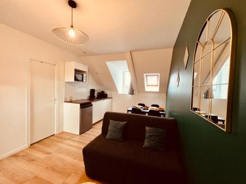 un soggiorno con divano e parete verde di L'Art Déco - Home Homy a Carhaix-Plouguer