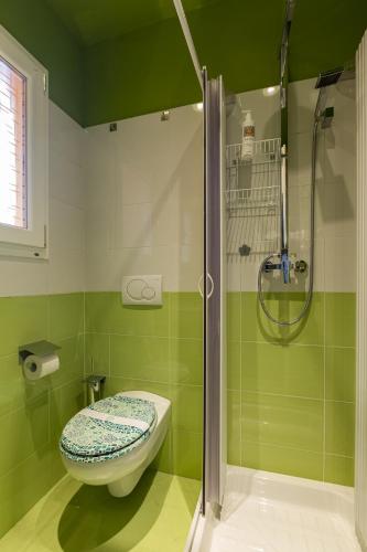 a green bathroom with a toilet and a shower at Bellagio Beautiful Oasi in Bellagio