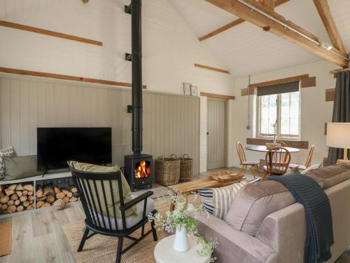 a living room with a couch and a fireplace at Oak Cottage - Fold Yards in Belper