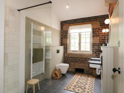 ein Badezimmer mit Waschbecken und Toilette und einem Fenster in der Unterkunft Oak Cottage - Fold Yards in Belper
