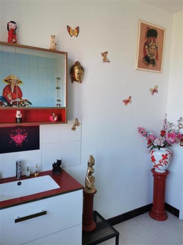 une salle de bain avec un lavabo et un miroir dans l'établissement audouard, à Saint-Aubin-sur-Mer