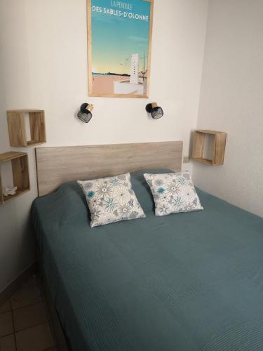 une chambre avec un lit avec deux oreillers dessus dans l'établissement l'orée du lac, à Talmont-Saint-Hilaire