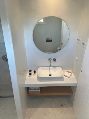 a bathroom with a sink and a mirror at Sohoro Olive in Ios Chora