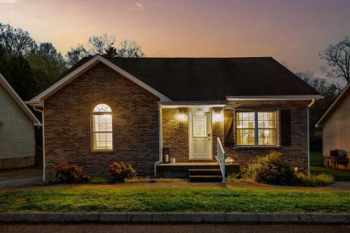 a brown brick house with a white door at 1 Mile to pkwy, Pets, Hot Tub, Creekside, Porch in Pigeon Forge
