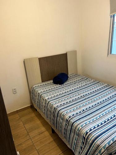 um quarto com uma cama com uma almofada azul em Casa São Francisco do Sul em São Francisco do Sul